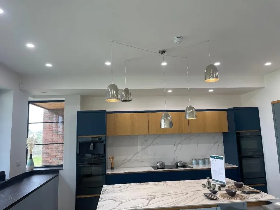 Pendant lighting installed above a kitchen island in a showroom fit-out